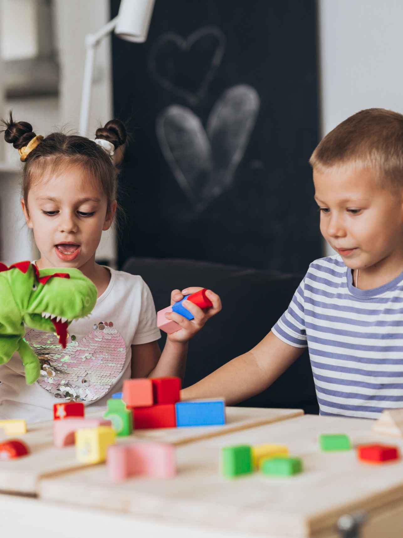 jongen en meisje spelen samen aan tafel met gekleurde houten blokken, Test of Playfulness-NL cursus HvA