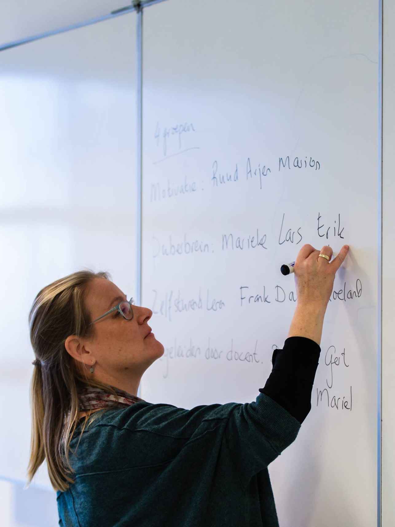 docent schrijft met een marker op het bord