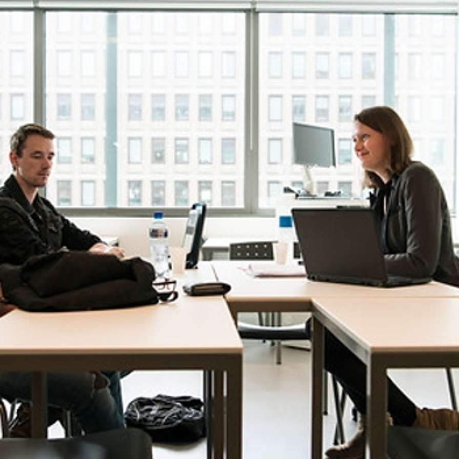 Personen voeren gesprek aan een tafel.