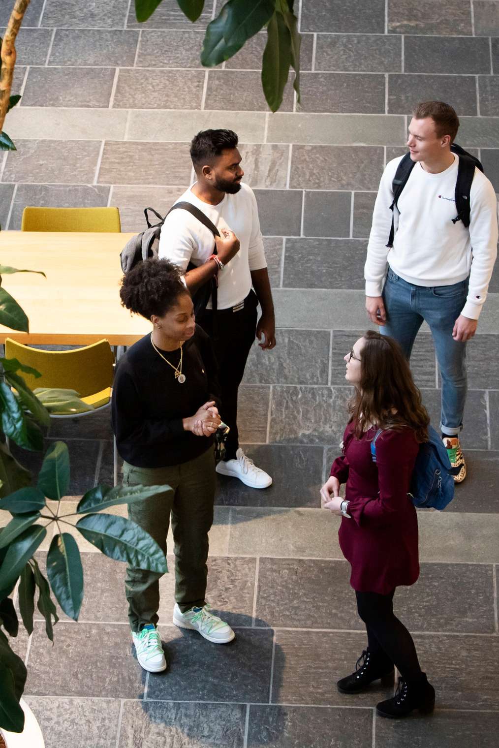 Four students in a hall on an open day