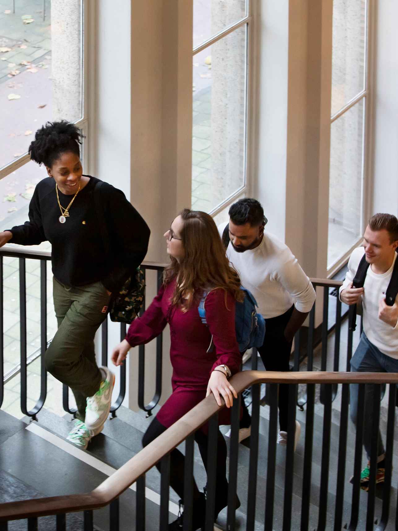 Twee studenten die via de trap het gebouw inlopen