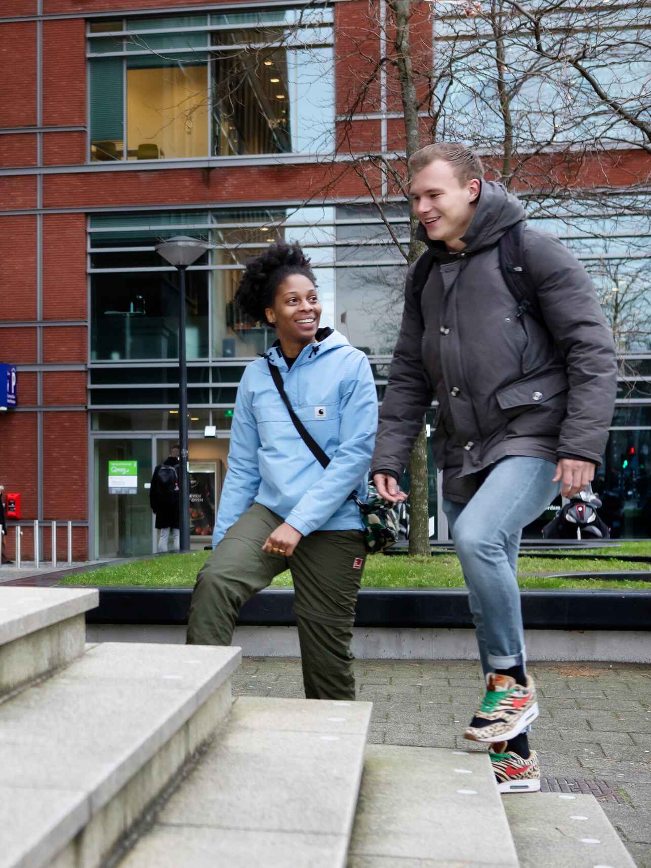 Twee studenten die via de trap het gebouw inlopen