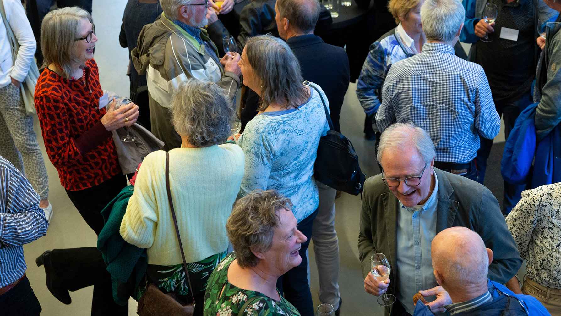 een groep oudere werknemers tijdens een borrel