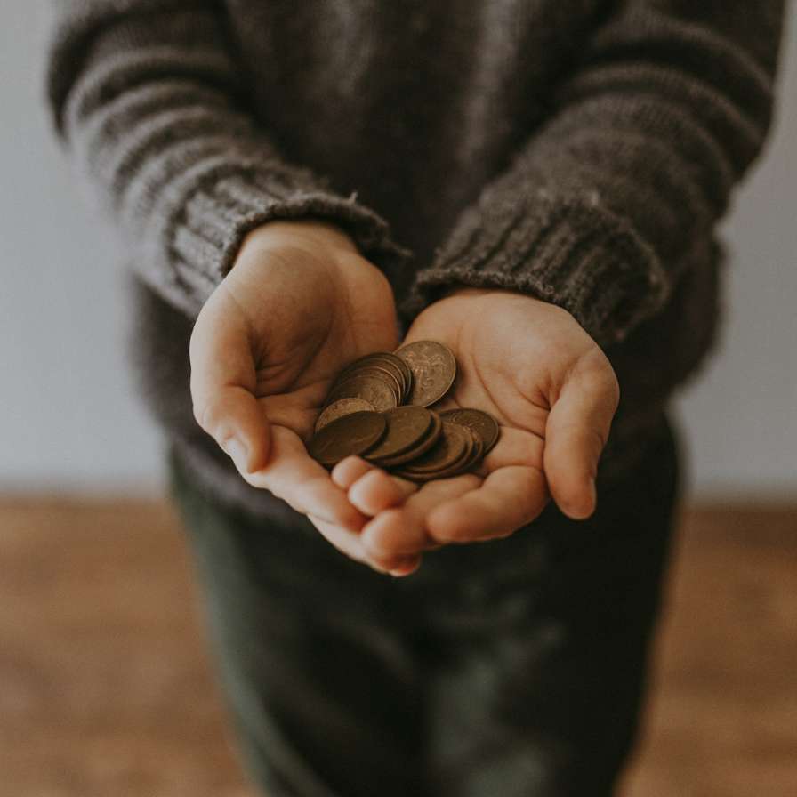 Persoon houdt stapel geld vast.