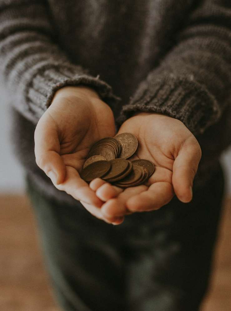 Persoon houdt stapel geld vast.