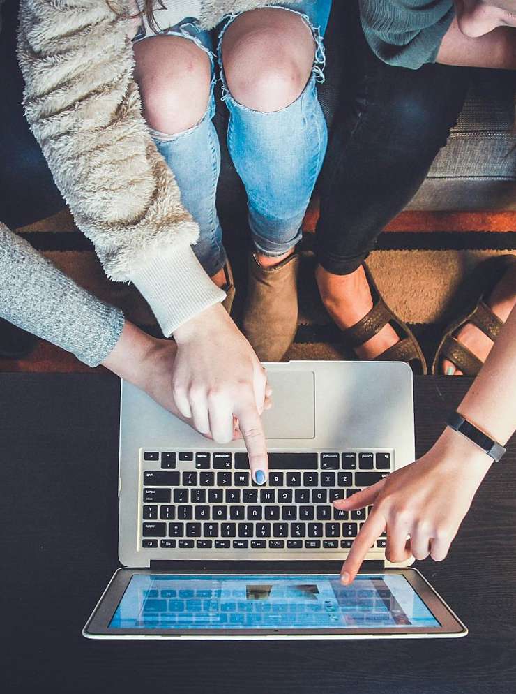 Person pointing at laptop.