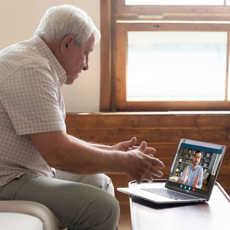 oudere man kijkt op laptop