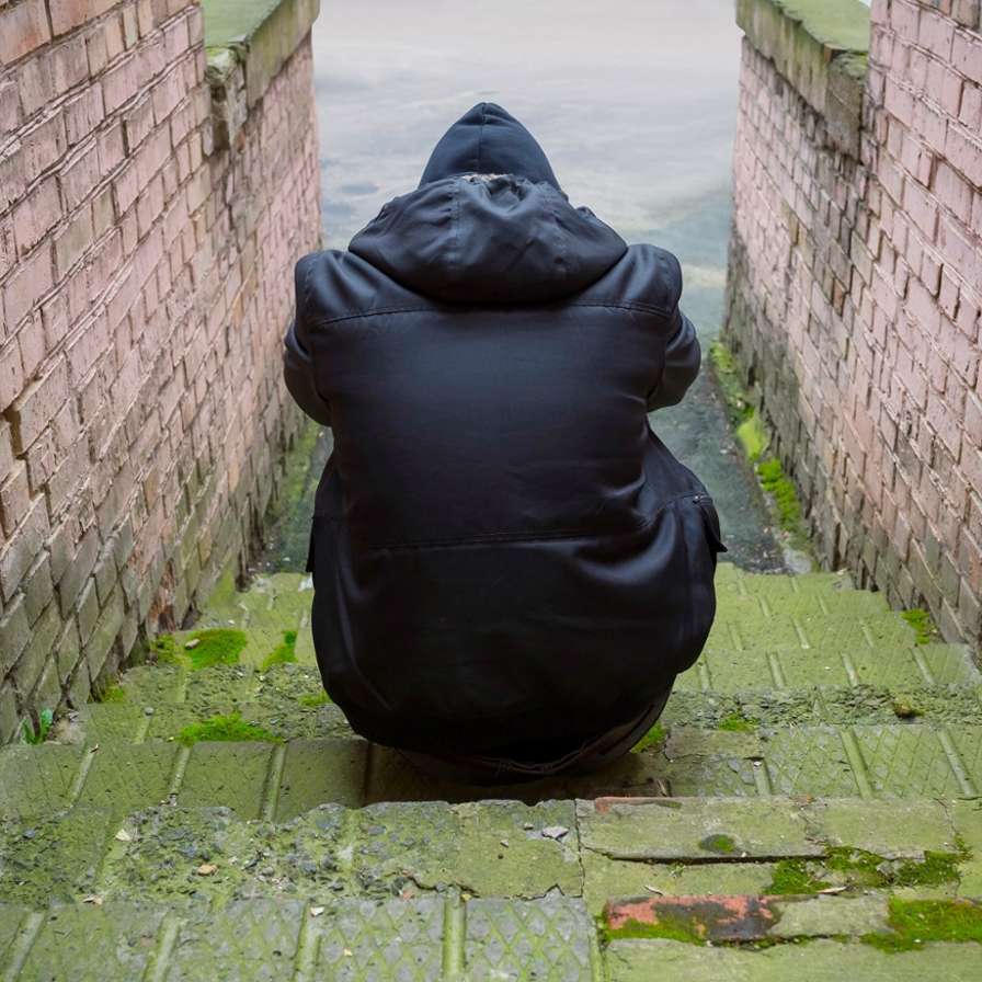 hva GGZ en verslavingspreventie voor jonge statushouders: we doen het samen. jongen op trap achterkant jas alleen problemen
