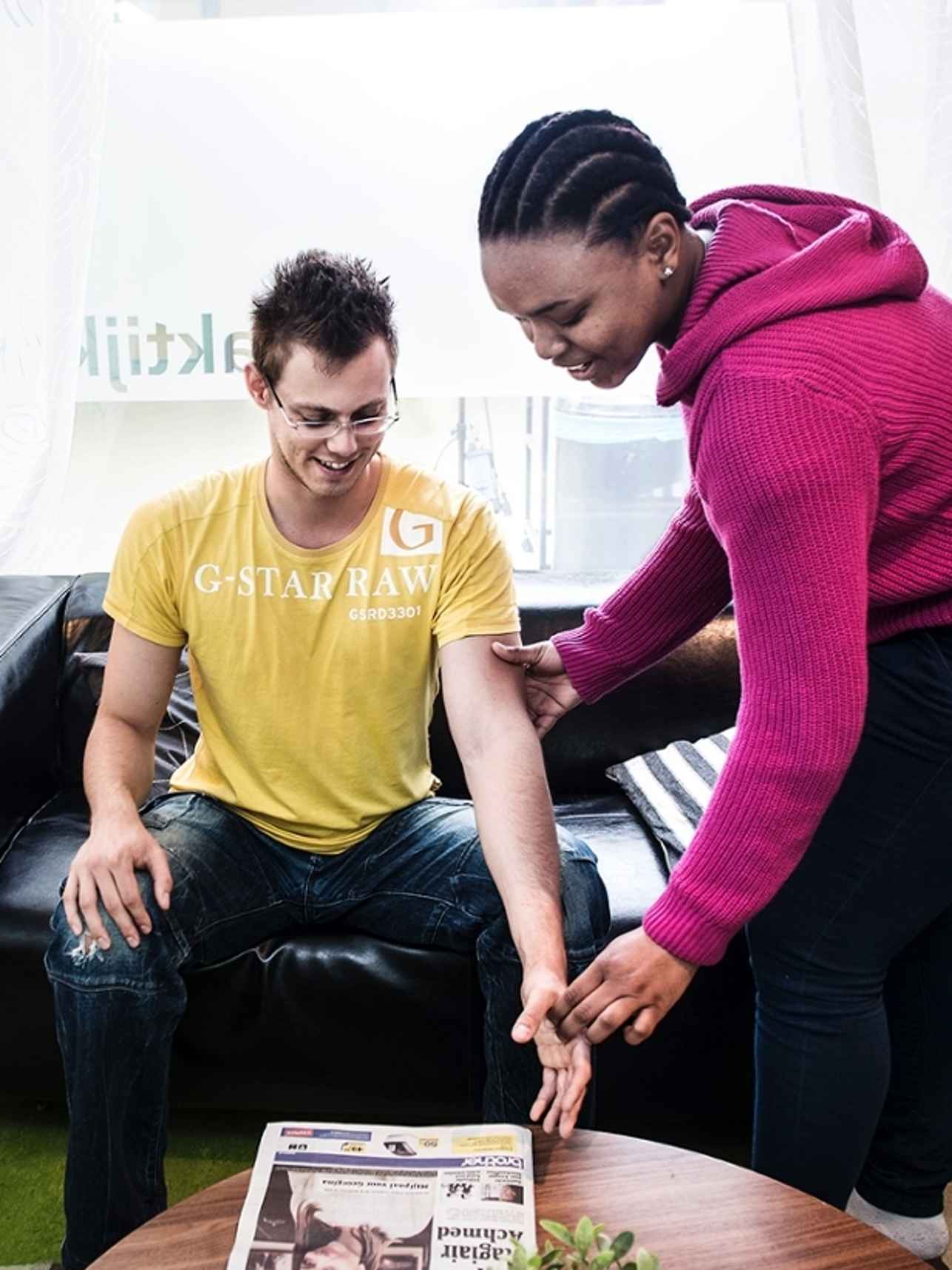 functional exercise therapist helps client standing up from couch