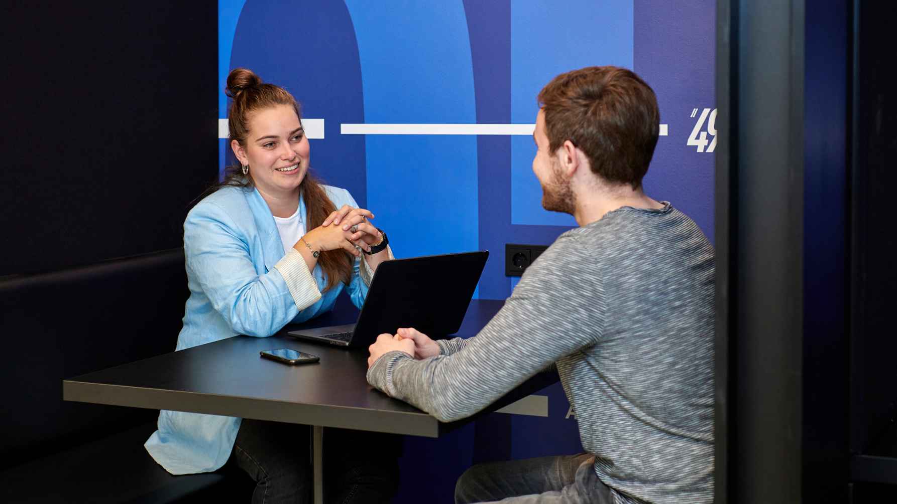 two Sport Studies students talking at a table