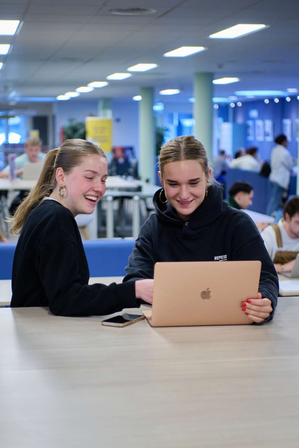 Studenten Sportkunde HvA achter laptop mediatheek