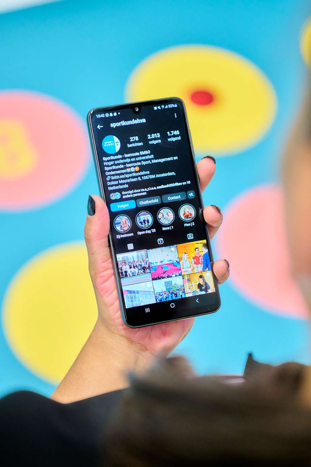 student kijkt op scherm smartphone naar Instagramkanaal Sportkunde HvA