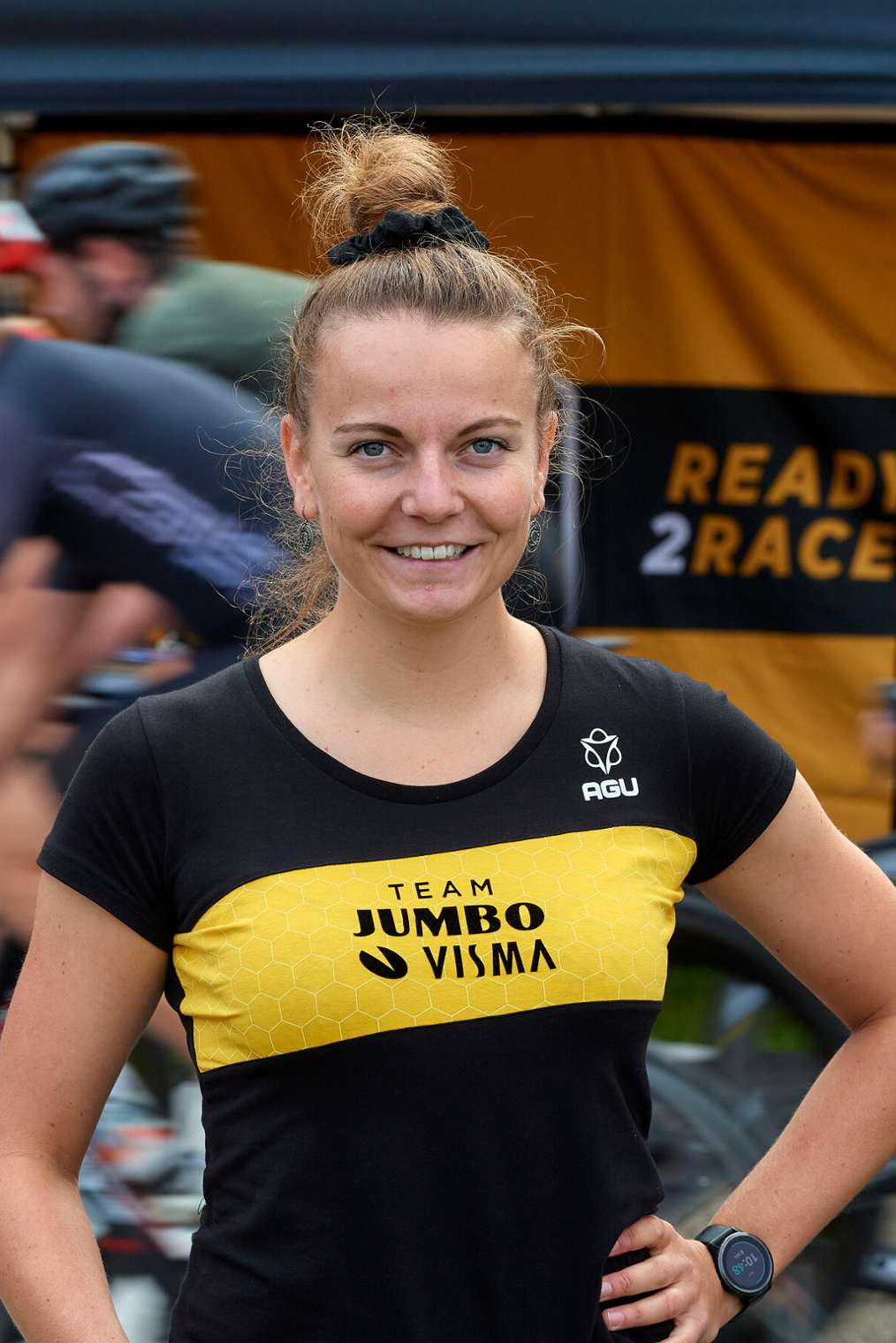 Student Sportkunde stage Jumbo Visma, op achtergrond wielrenners die langsfietsen, HvA