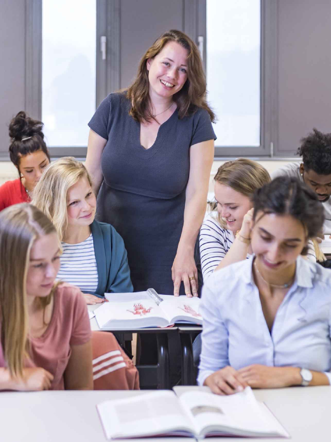 Docent staat achter studenten in klaslokaal, schakelprogramma master GGZ-Verpleegkunde HvA