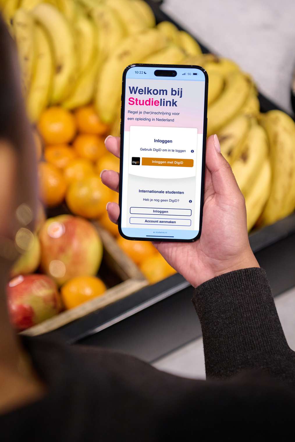 student met mobiel in hand inschrijven studielink