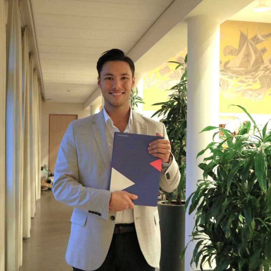 Alumnus Robin Lefeu houdt trots zijn diploma voor