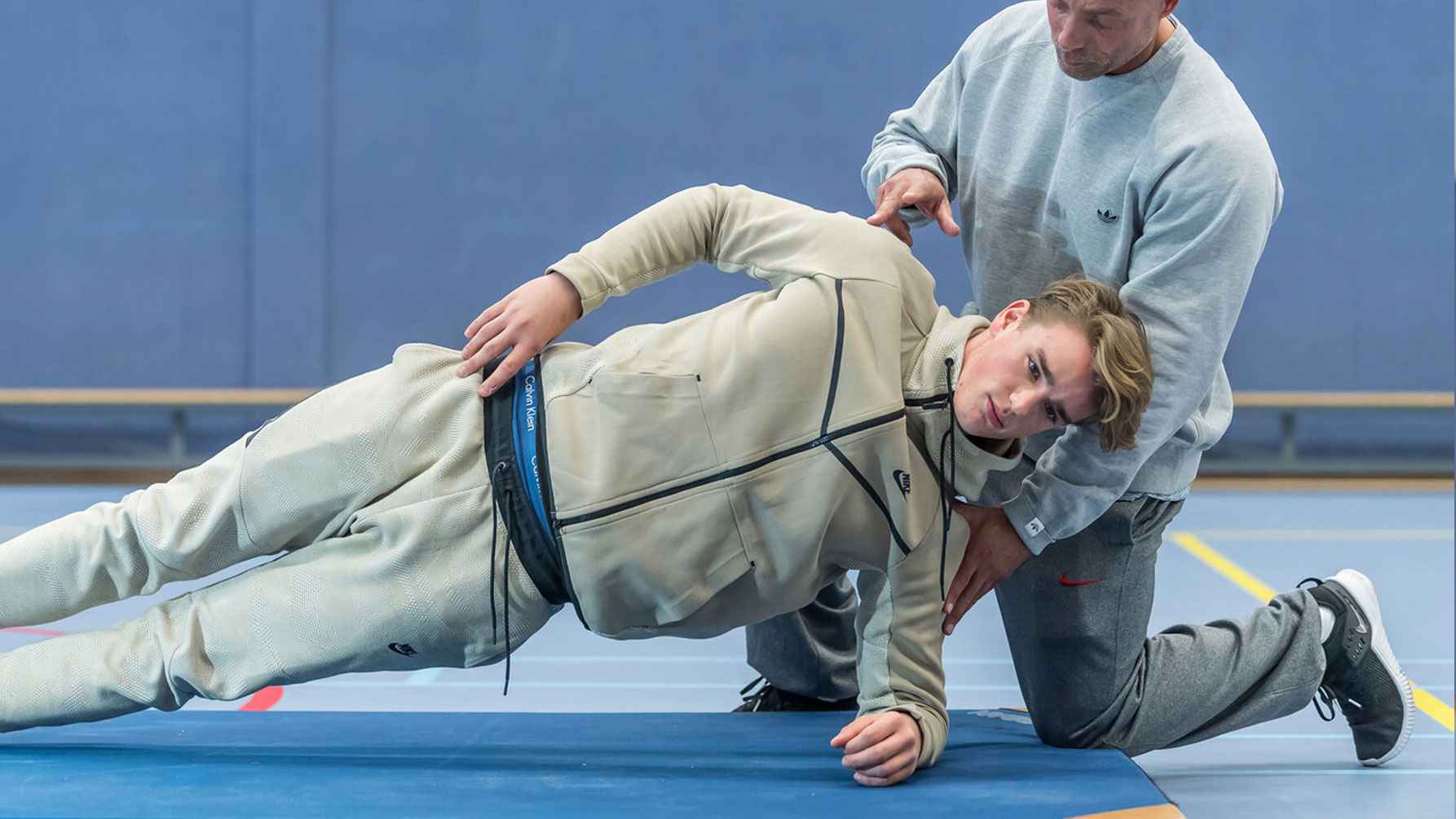 Man on floor with trainer in exercise position