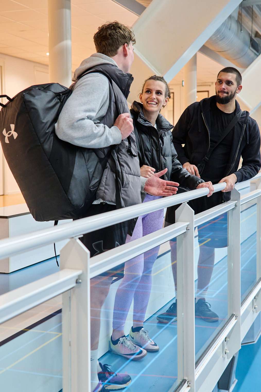 Drie studenten kletsen in gymzaal ALO