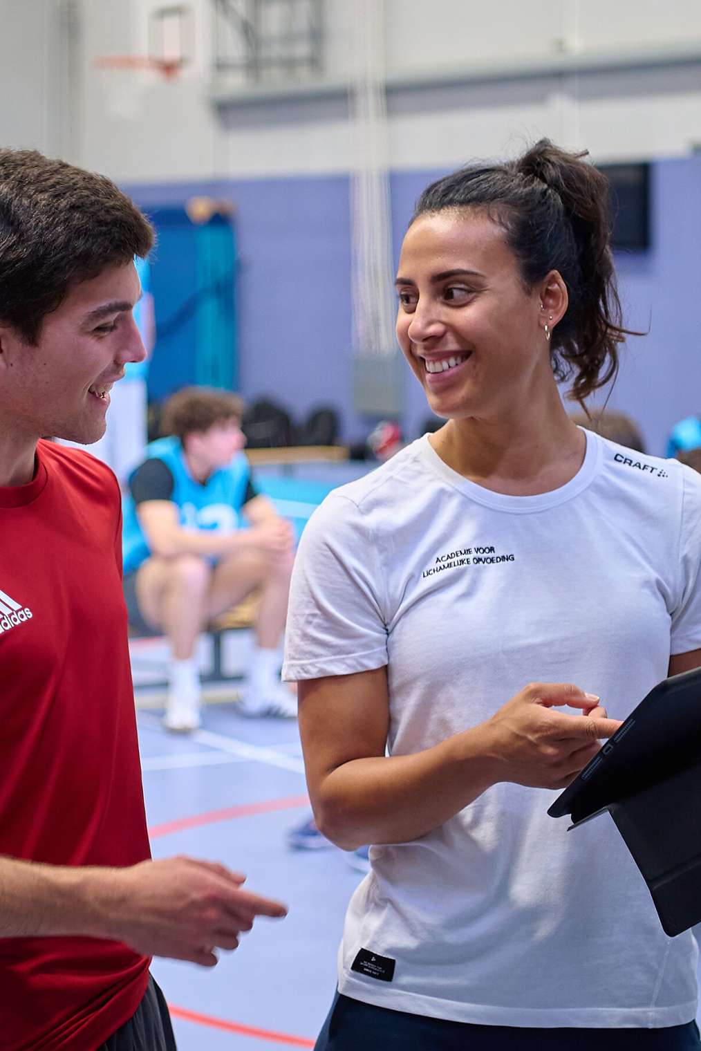 Twee ALO-studenten in gesprek in gymzaal