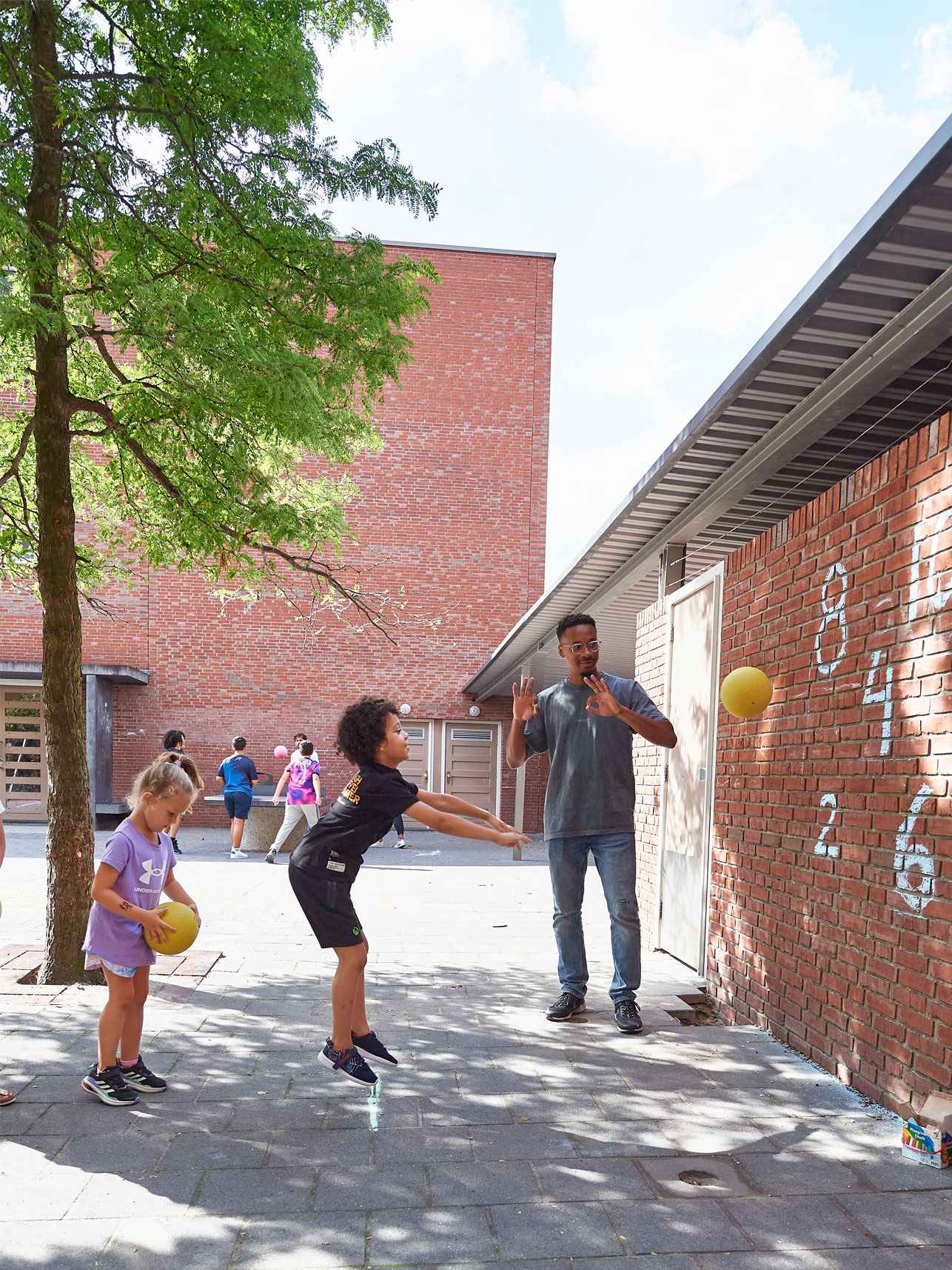 Student met kinderen op schoolplein