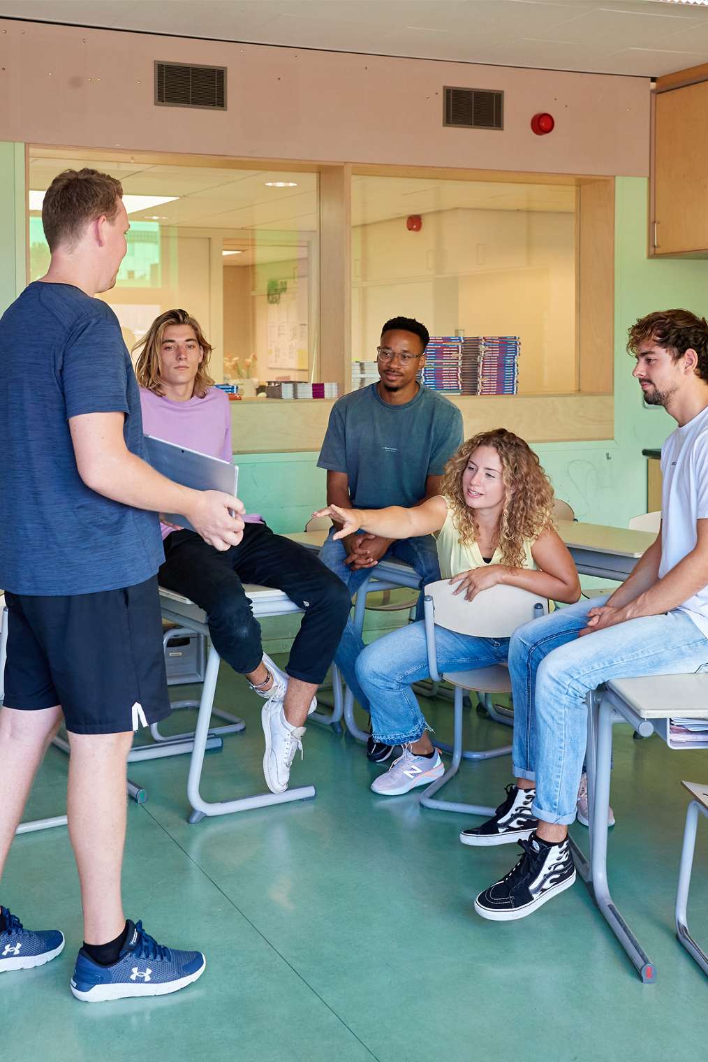 Docenten met studenten in gesprek in klaslokaal