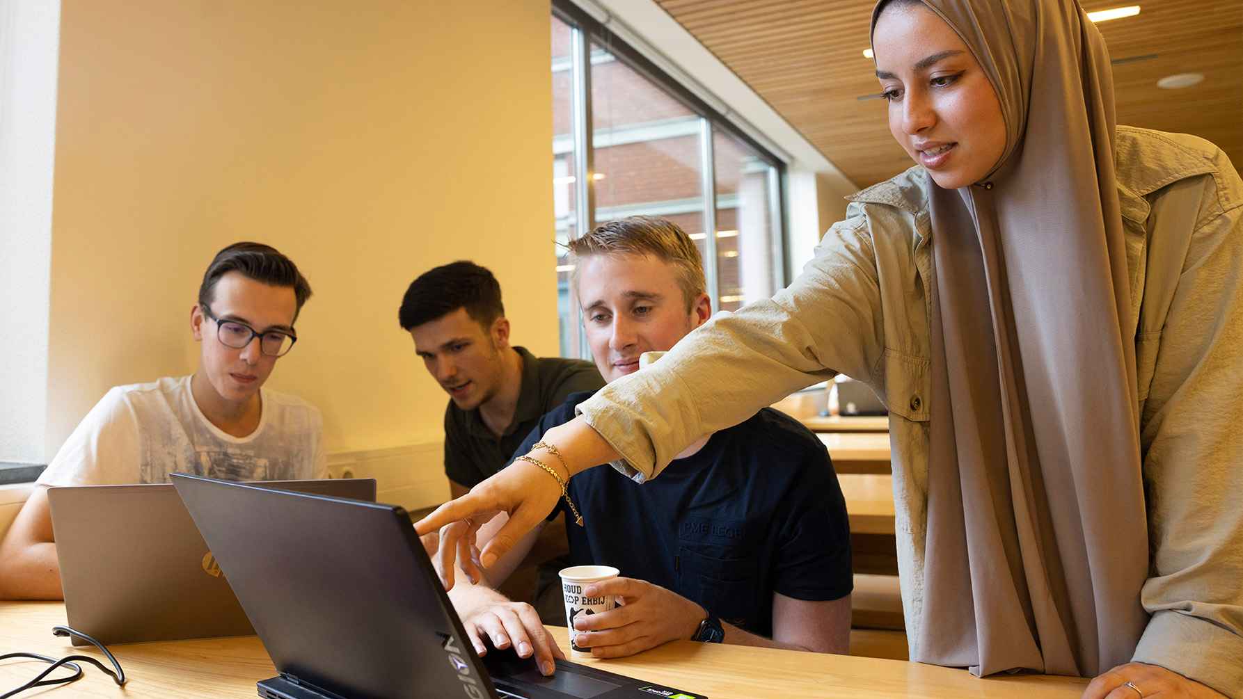 Afbeelding van studenten die samen aan het programmeren zijn.