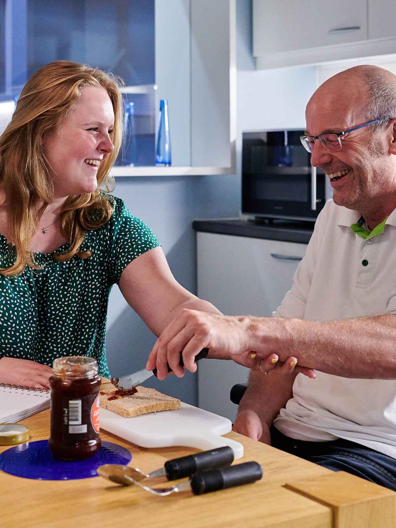 Ergotherapeut helpt mannelijke cliënt met brood smeren, Ergotherapie HvA