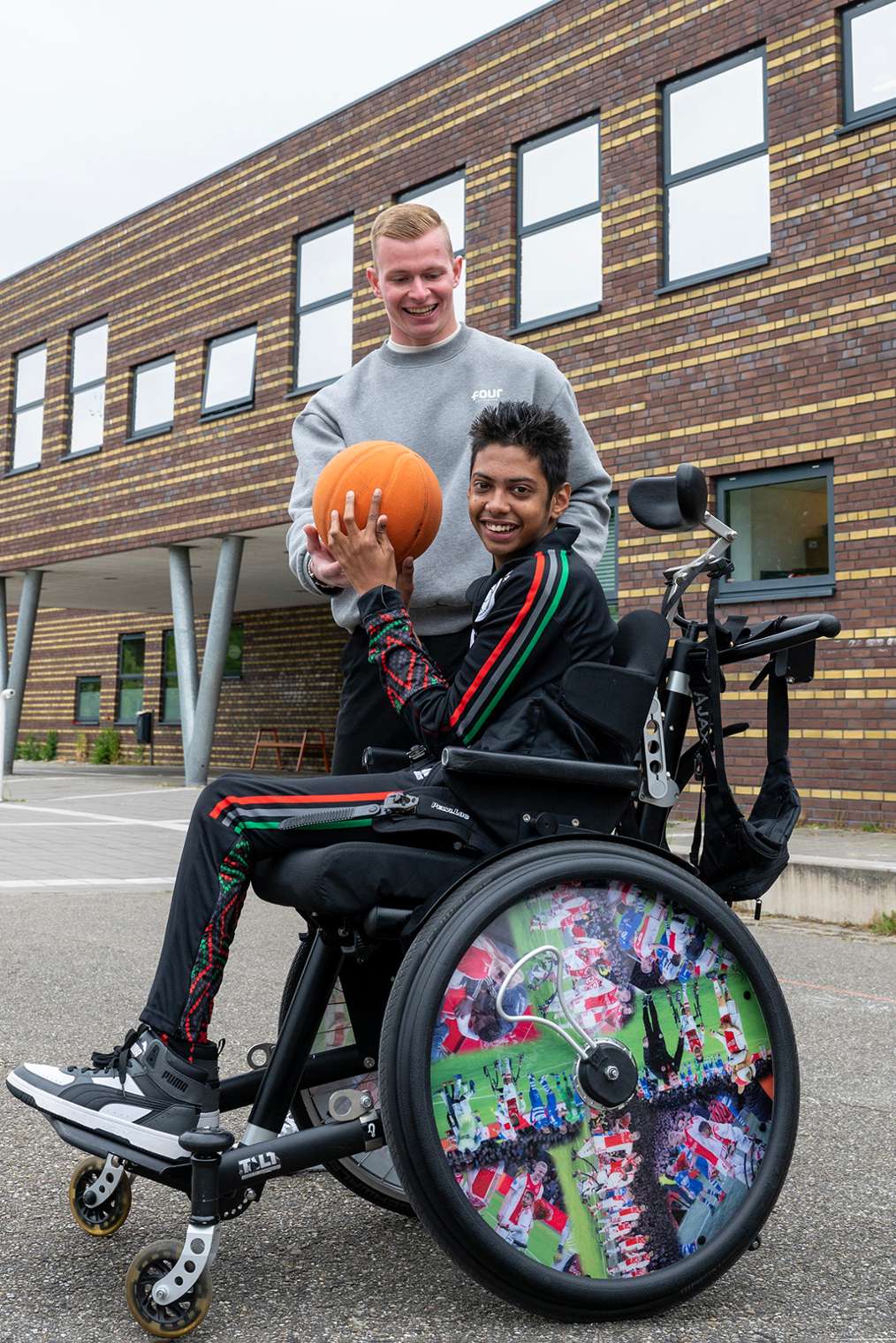 Ergotherapeut, naast jongen in rolstoel met basketbal, Ergotherapie HvA