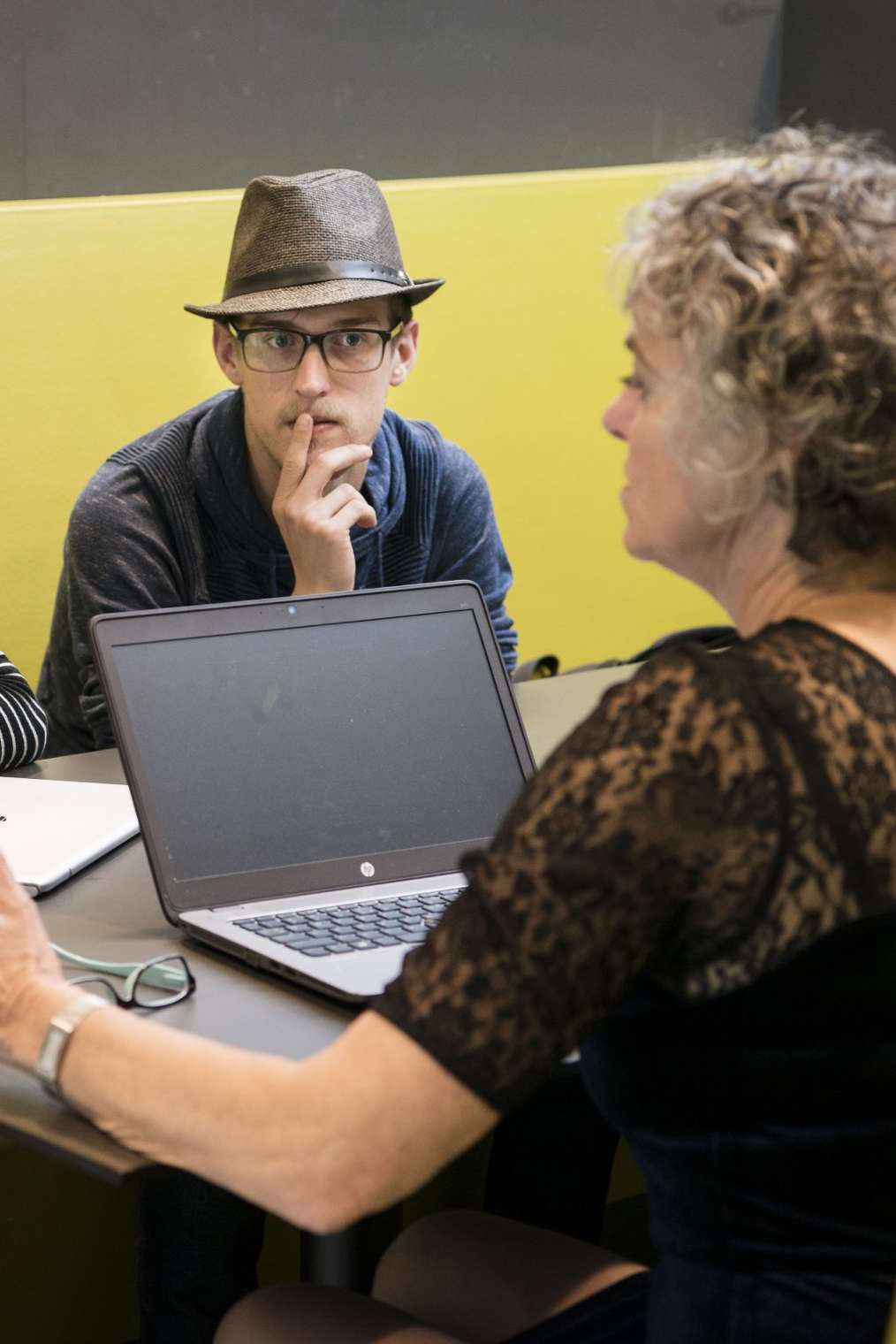 Drie studenten aan tafel met elkaar in gesprek