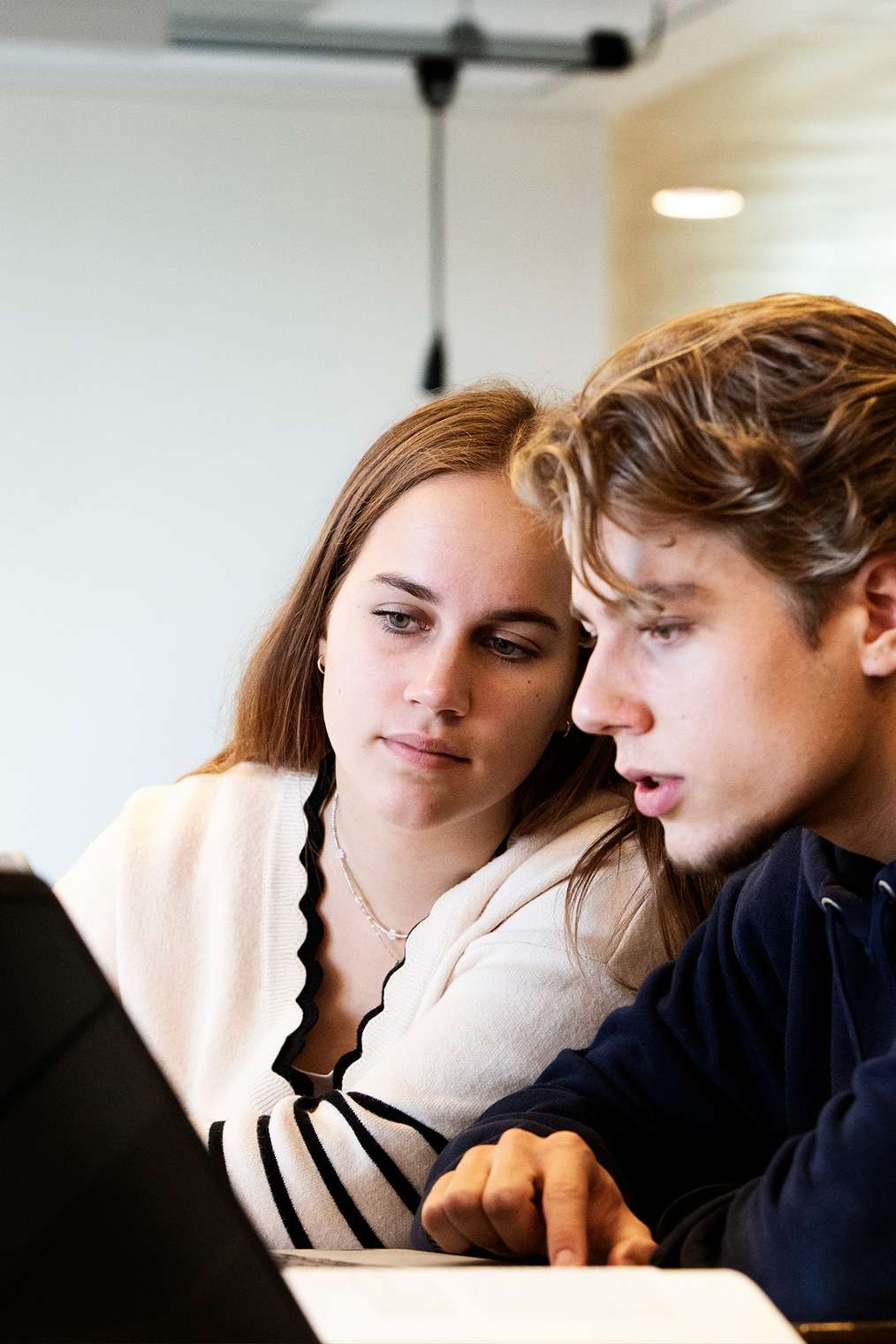 Twee studenten die via de trap het gebouw inlopen