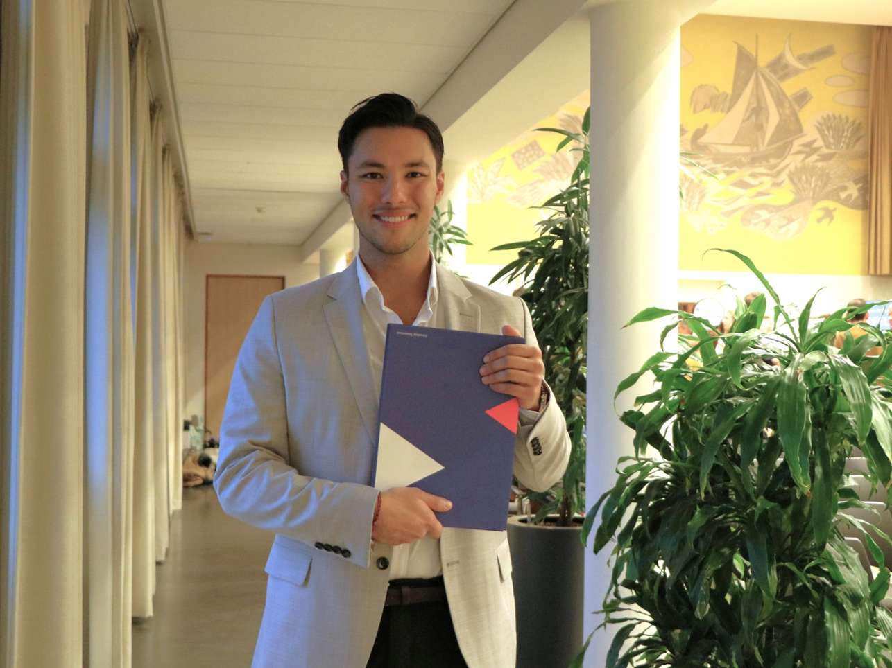Alumnus Robin Lefeu houdt trots zijn diploma voor