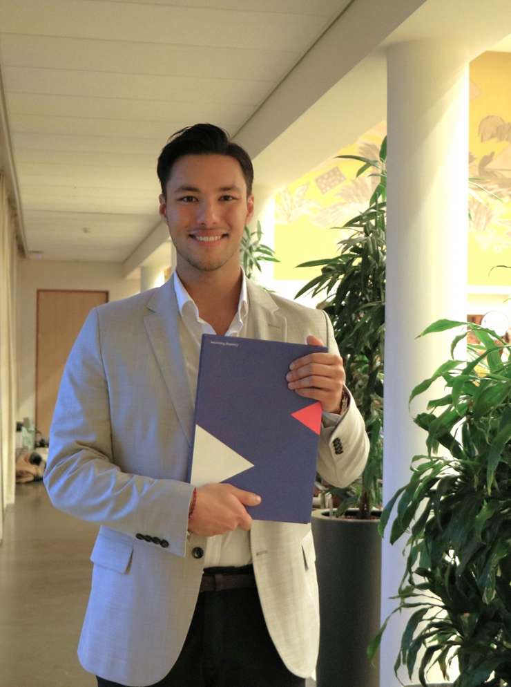 Alumnus Robin Lefeu houdt trots zijn diploma voor