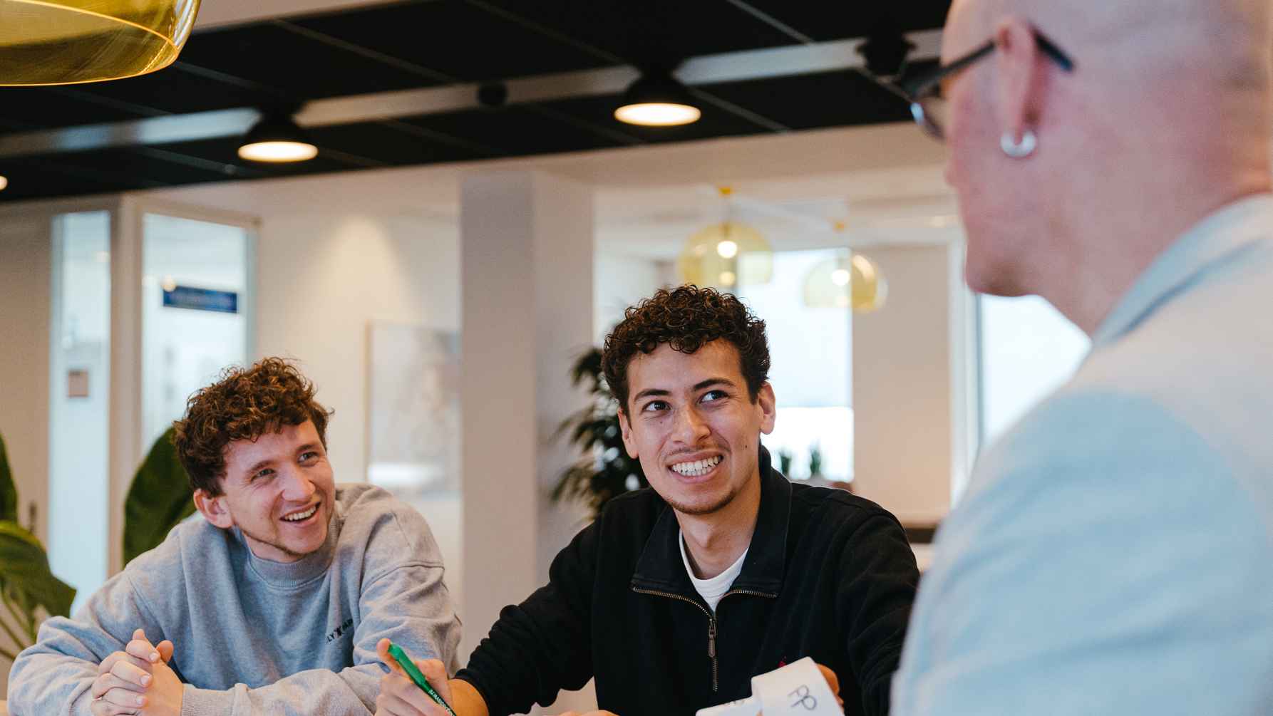 Benjamin en Brian praten met een docent