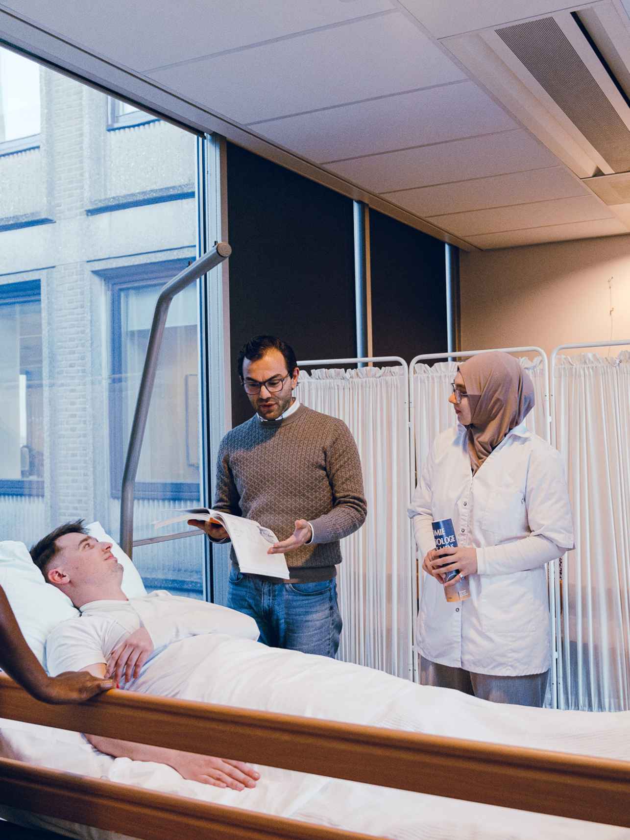 studenten gezondheidszorg en welzijn in beroepspraktijk, naast een bed met patiënt