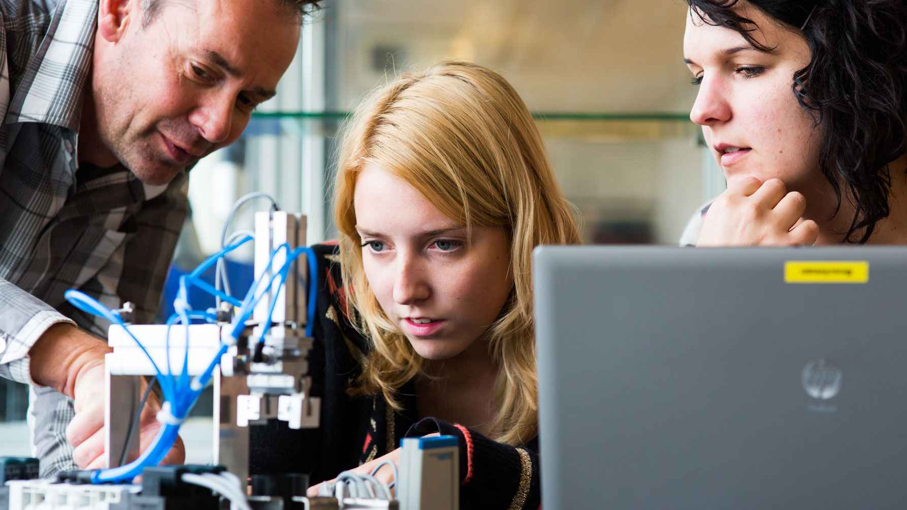 Studenten en docent aadachtig te werk in in werkplaats