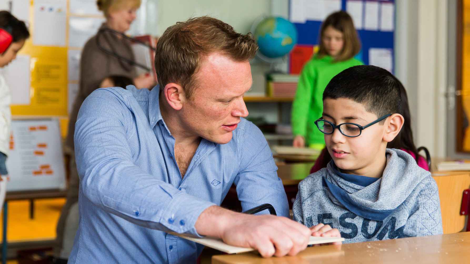 Leraar geeft uitleg aan leerling