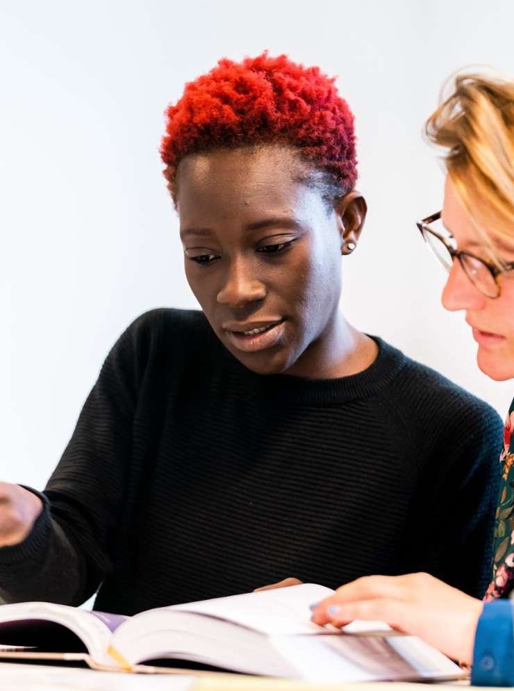 2 vrouwen stemmen af kijkend naar boek