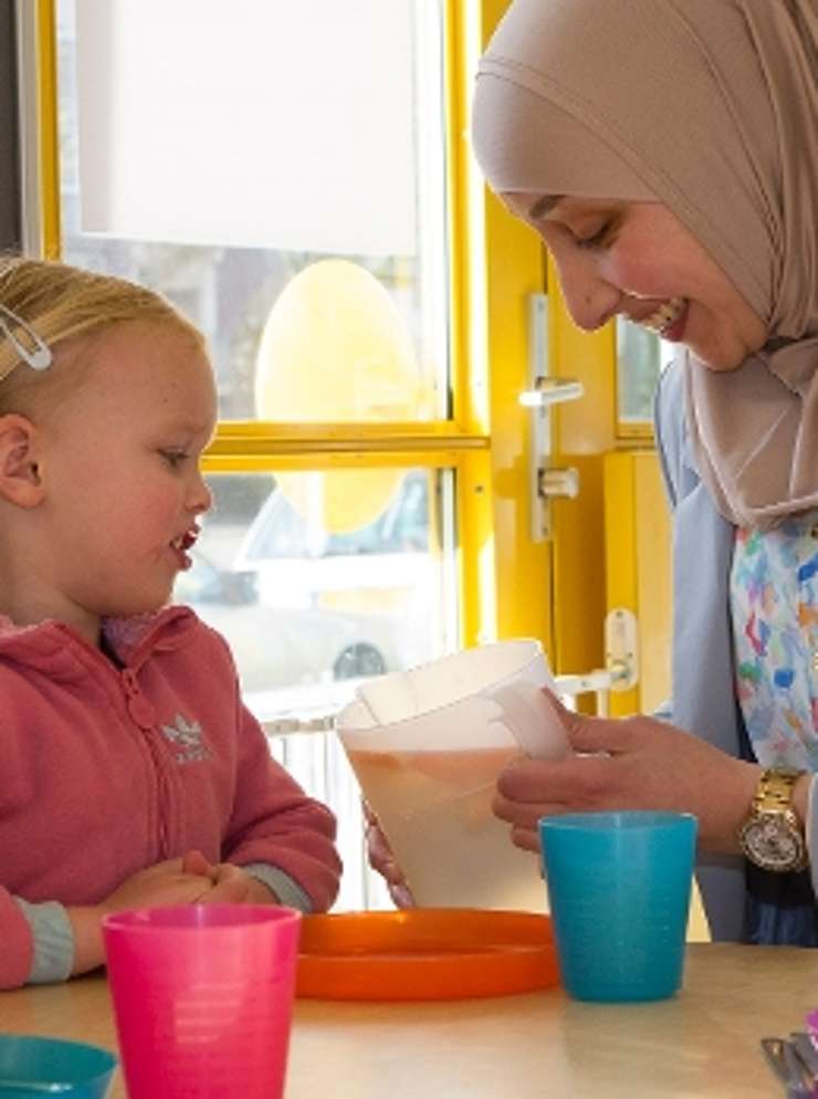 Vrouw met kinderen op een opvang.