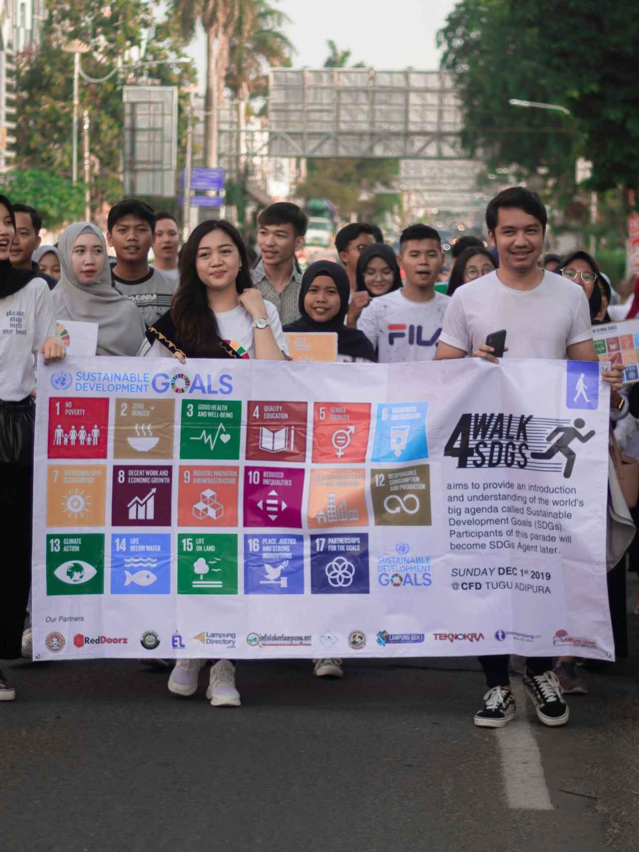 Group of people holding banner with the SDG goals.