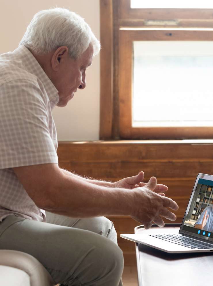 oudere man kijkt op laptop