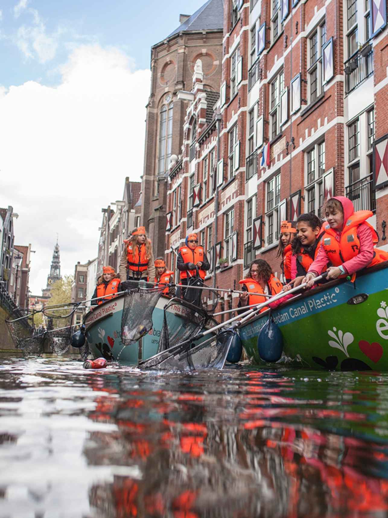 Kinderen vissen plastic uit de gracht