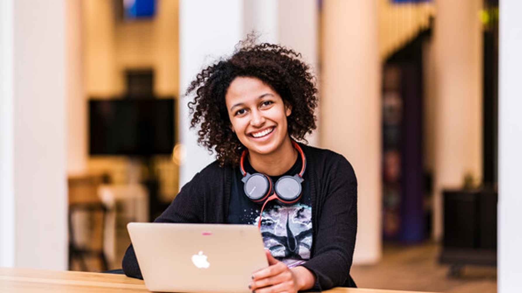 lachende studente achter laptop