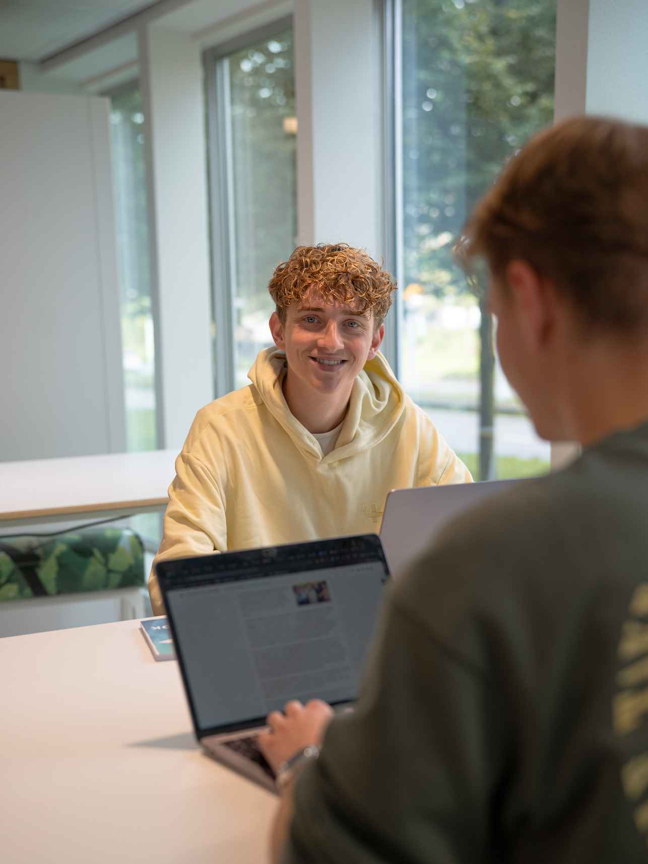 Studenten tegenover elkaar aan het werk