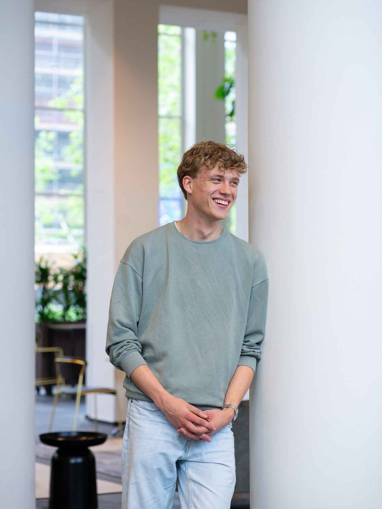 Mannelijke student leunend tegen pilaar op het Kohnstammhuis