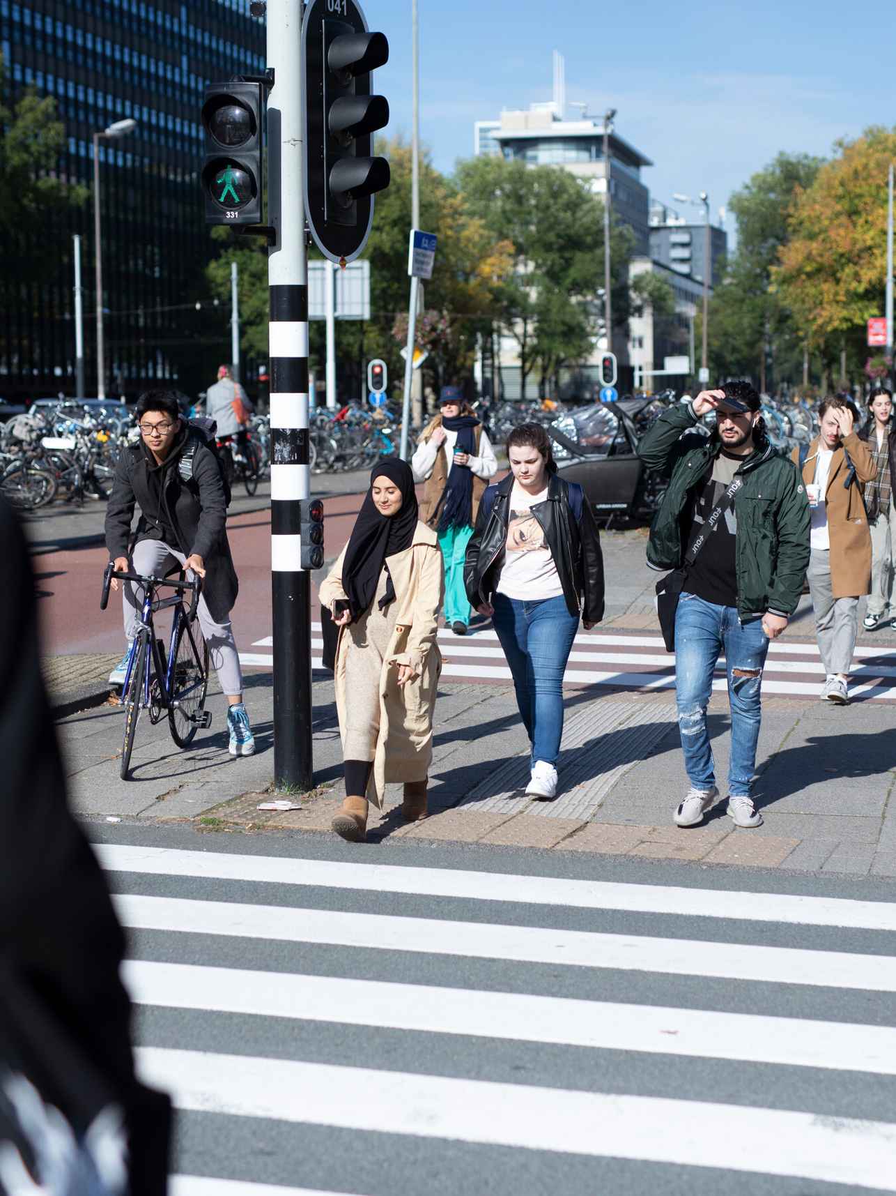 personen met diverse achtergrond steken zebrapad over